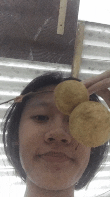 a woman is holding two potato chips over her eyes