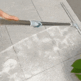 a person is using a squeegee to clean a tile floor .
