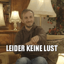 a man sitting on a couch with the words leider keine lust on the bottom right