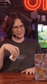 a man wearing glasses and a microphone is pouring something into a cup that says g on it