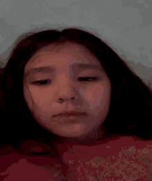 a young girl is making a funny face with her hand on her face .