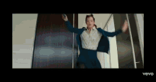 a woman in a suit and skirt is jumping in the air while holding a cell phone .
