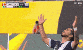 a soccer player celebrates with his hands in the air