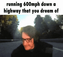 a man wearing glasses is running 600mph down a highway