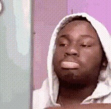 a man wearing a white hoodie looks at himself in the mirror .