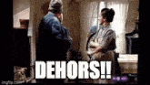 a man and a woman are standing next to each other in a room with the words dehors written above them .