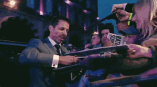 a man in a suit is signing autographs for fans with a sign that says bruce springsteen on it