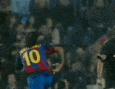 a soccer player with the number 10 on his jersey is being tackled by another player .
