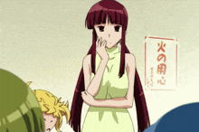 a girl in a yellow dress is standing in front of a sign that says ' 火 の 用心 '