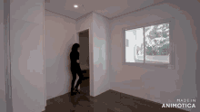 a woman stands in an empty room with the words made in animotica on the bottom right