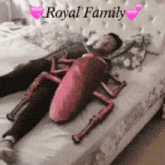a man is laying on a bed with a stuffed cockroach on his stomach ..