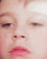 a close up of a child 's face with a pink lip and a pink nose .