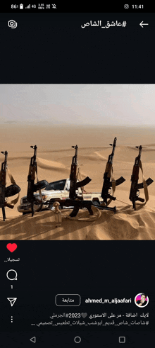 a phone screen shows a picture of guns in the sand