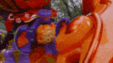 a close up of a purple and orange toy with a purple button