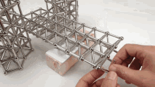 a person is holding a piece of metal that looks like a grid