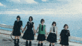 a group of girls holding hands with one wearing a vest that says abc on it