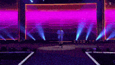 a man stands on a stage in front of a large screen that says netflix