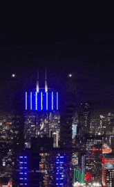 an aerial view of a city at night with a triangle shaped building in the distance that says ' xxx ' on it