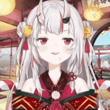 a girl with long white hair and horns is making a funny face in a room .
