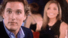 a man in a suit and a woman in a black dress are looking at each other .