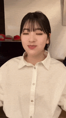 a woman wearing a white shirt is making a funny face
