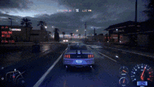 a ford mustang is driving down a wet street at night .