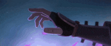 a person 's hand is reaching out towards a purple object .