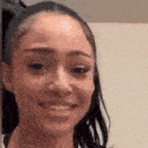 a close up of a woman 's face with a ponytail smiling .