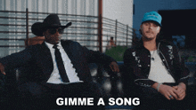 two men sitting on a couch with the words gimme a song written on the bottom