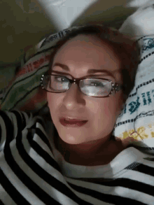 a woman wearing glasses and a black and white striped shirt