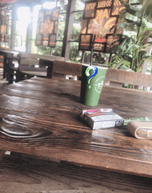 a green cup with a question mark sits on a wooden table