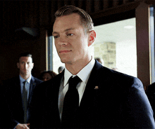 a man in a suit and tie has a badge on his chest that says ' congressman '