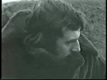a black and white photo of a man with a fur coat around his neck