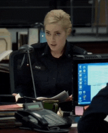 a female police officer named peck sits at a desk