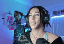 a woman wearing headphones stands in front of a wall with posters on it that say sex