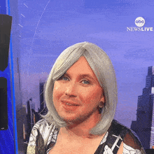 a man in a wig is standing in front of a abc news live sign