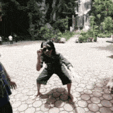 a man wearing sunglasses stands on his knees on a tiled floor