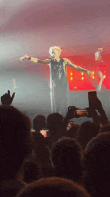 a man singing into a microphone with his arms outstretched