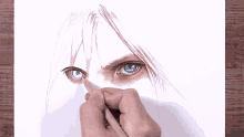 a person is drawing a woman 's eye with a blue pencil on a piece of paper .