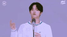 a young man stands in front of a microphone with the words wwc on the bottom