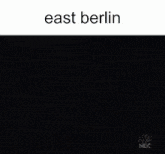 a woman is standing in front of a nightstand with the words east berlin on the bottom