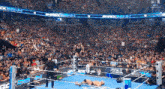 a wrestler is jumping over another wrestler in the middle of a wrestling ring