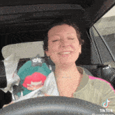 a woman in a car with a tattoo that says heaven on her neck