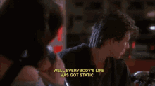 a man talking to a woman with the words well everybody 's life has got static
