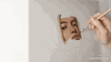 a person is painting a picture of a woman 's face with a brush .