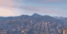 a plane is flying over a city and mountains in the background