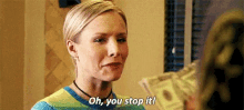a woman is holding a pile of money and saying `` oh , you stop it '' .