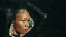 a woman with a tattoo on her forehead is wearing earrings