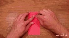 a person is holding a red envelope with the words made in animatica on the bottom