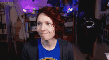 a woman with red hair wearing a blue shirt that says tomprince on it